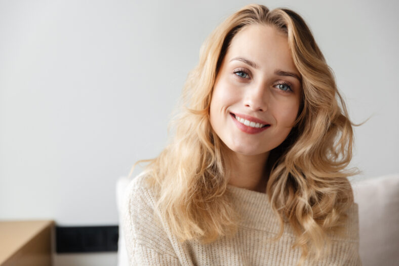Image of a beautiful positive optimistic young woman posing indoors at home.