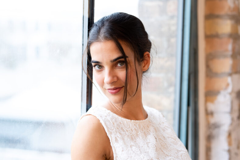 Interior fashion portrait of a beautiful young woman in a dress..