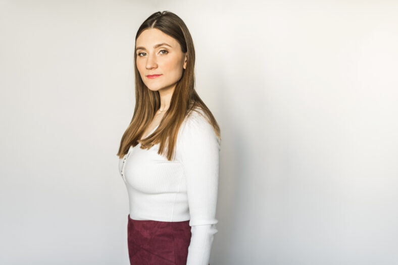 young woman stands on a white background