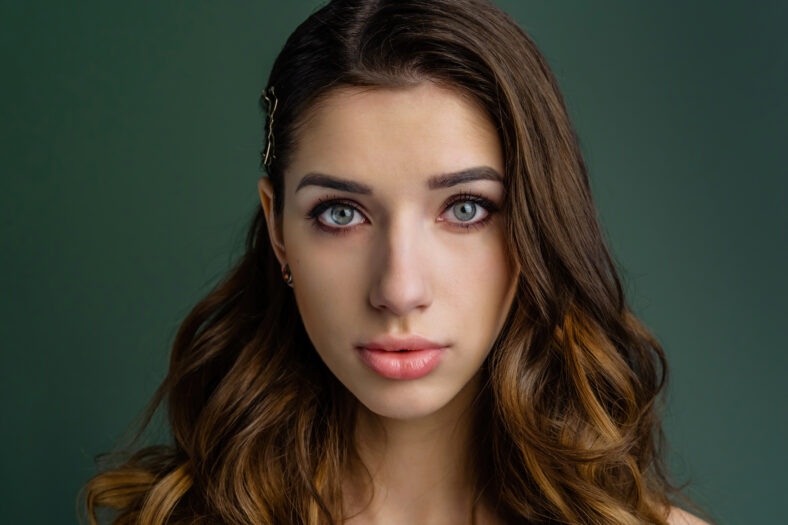 Beautiful girl bride in front of the camera, sensual look. Beautiful make-up, professional light. Look straight at the camera. Close-up.