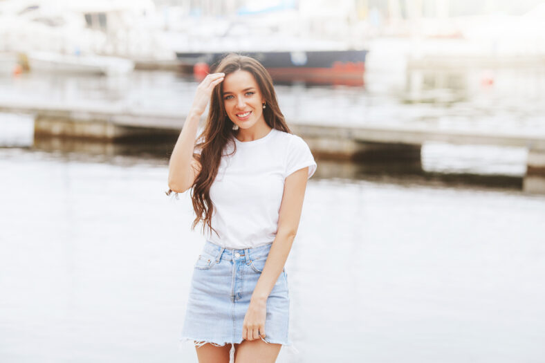 Young beautiful happy woman walks on beach in marina. Positive, travel, freedom. Europe