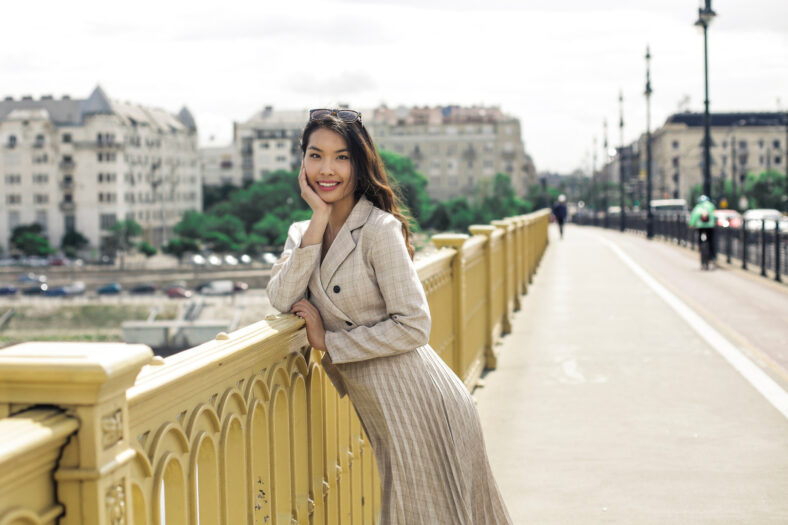 La mujer elegante camina por la ciudad