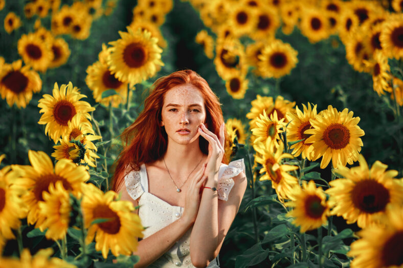 niña joven en girasoles en un día soleado de verano