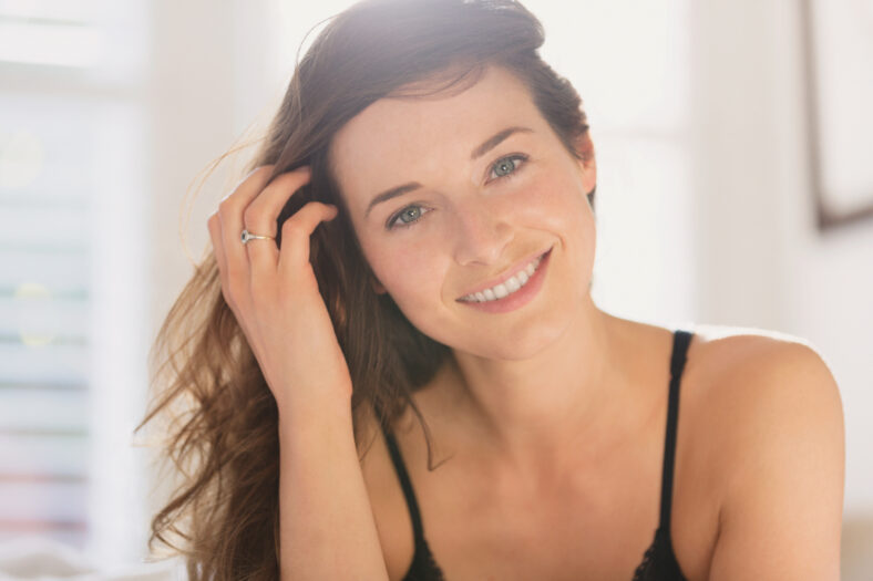 Portrait smiling woman with hand in hair