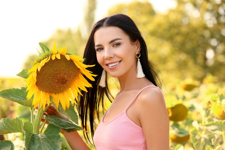 Hermosa mujer joven en campo de girasol