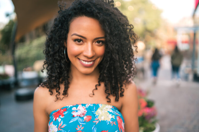 Portrait of beautiful afro american latin confident woman laughing in the street. Outdoors.