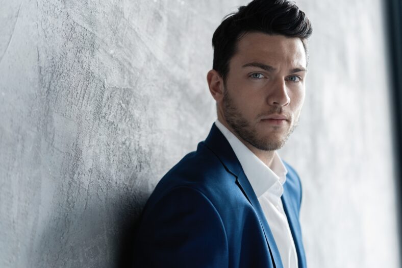 Handsome man wear blue suit isolated on grey background
