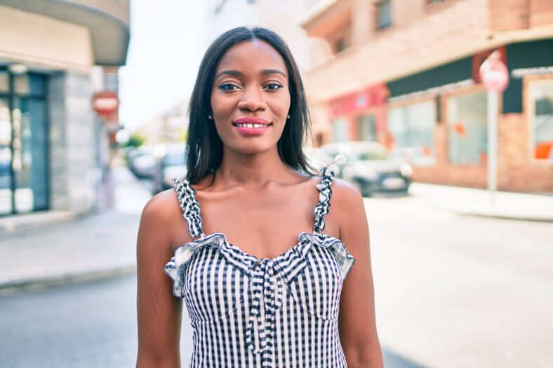 Young african american woman smiling happy walking at street of city