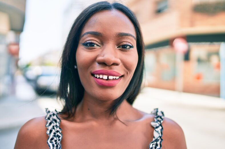 Young african american woman smiling happy walking at street of city