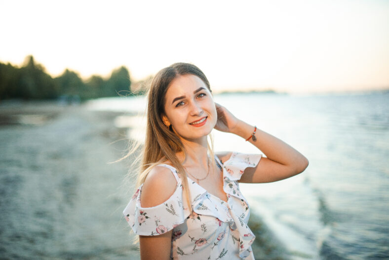 Blonde girl in summer light dress in summer outdoors.