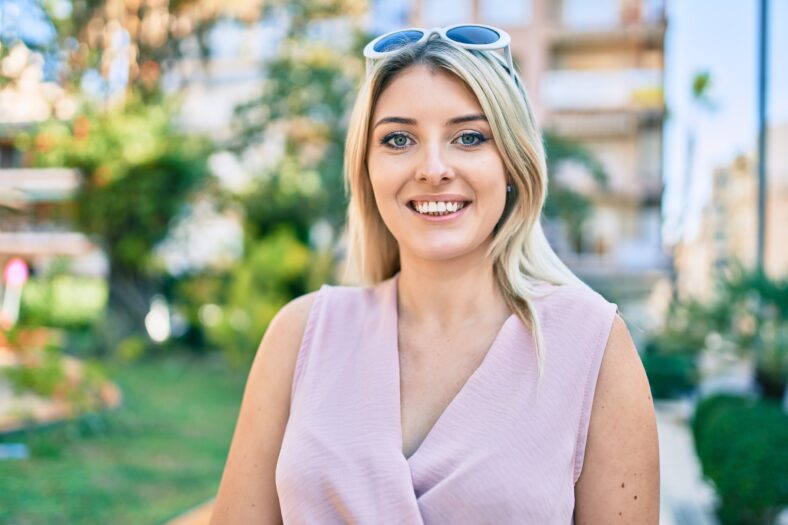 Young blonde woman smiling happy walking at the city.
