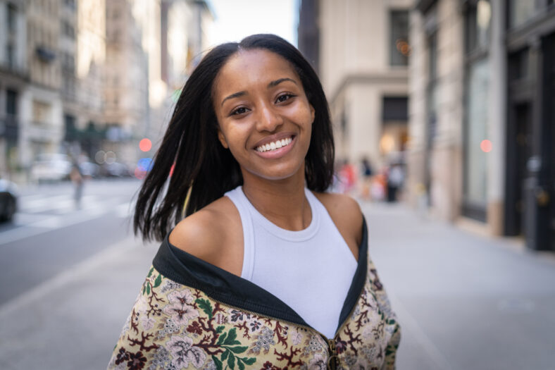 Young black woman in city flirting with camera smile face