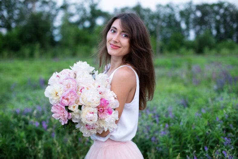 woman holding a bouquet of peonies