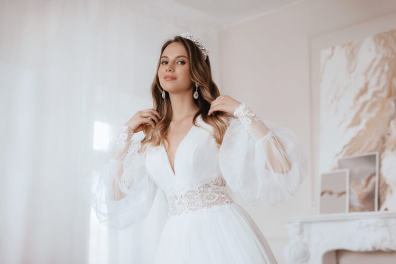 Beautiful brunette bride with light make-up in white dress in an exquisite interior