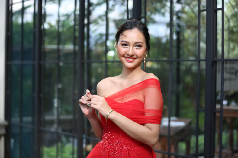 Young Asian Woman in a beautiful red dress looking at camera with smile. Fashion model, bride or pre-wedding concept.
