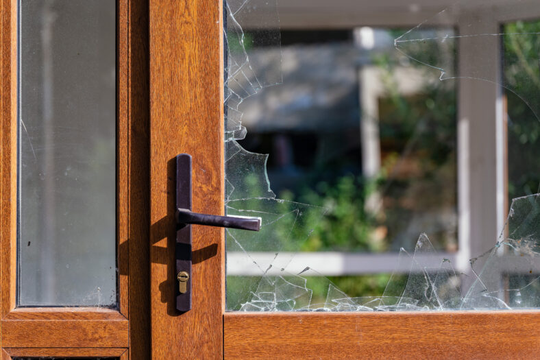 Modern door with handle and broken glass. Abandoned and dirty.