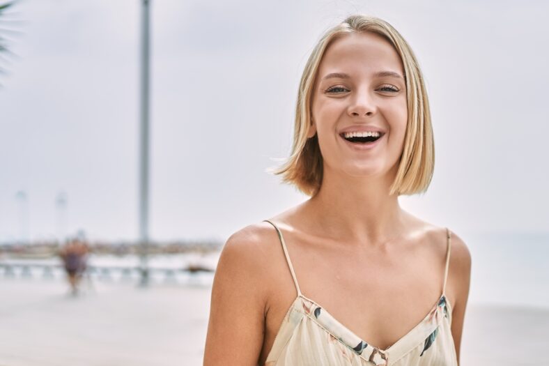 Young beautiful woman smiling confident by the sea