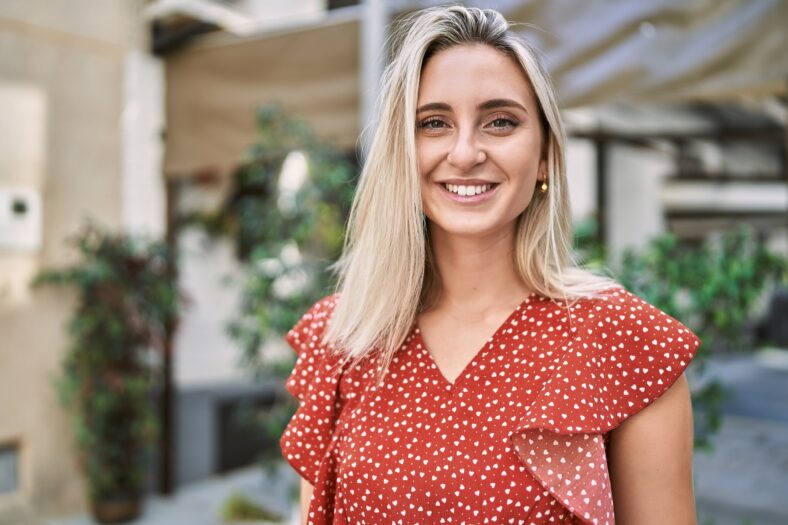 Young blonde girl smiling happy standing at the city.