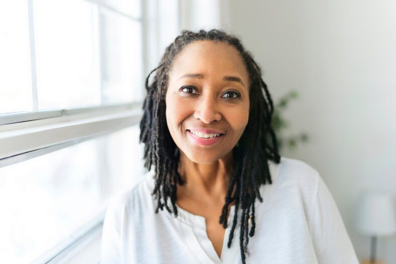 A Portrait of an african woman in front of a white window