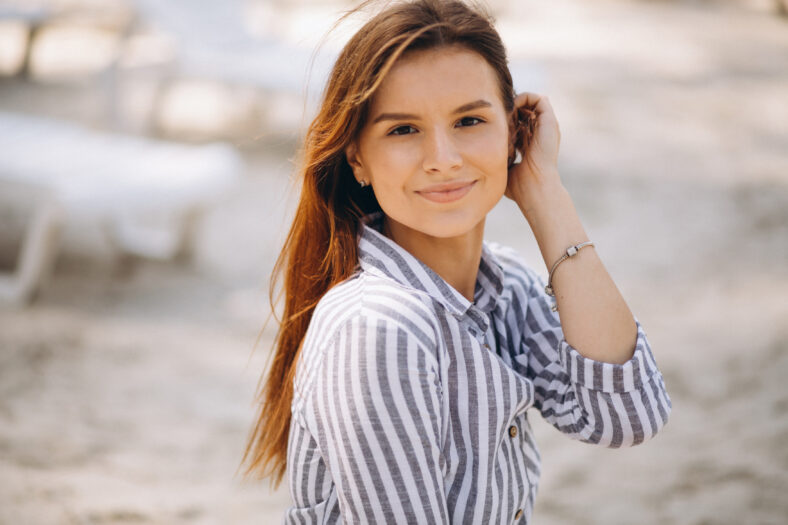 Young woman in dress resting at the beach