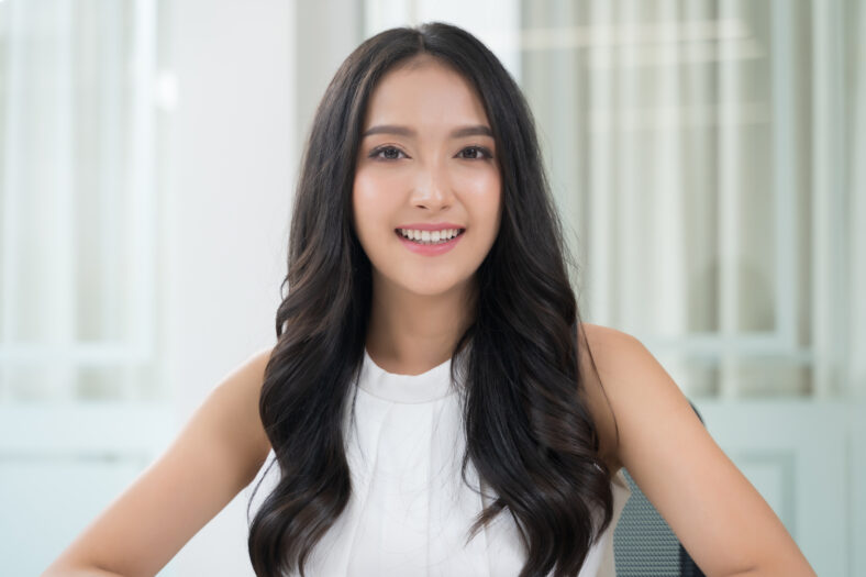 Close up portrait young Asian woman smiling in office
