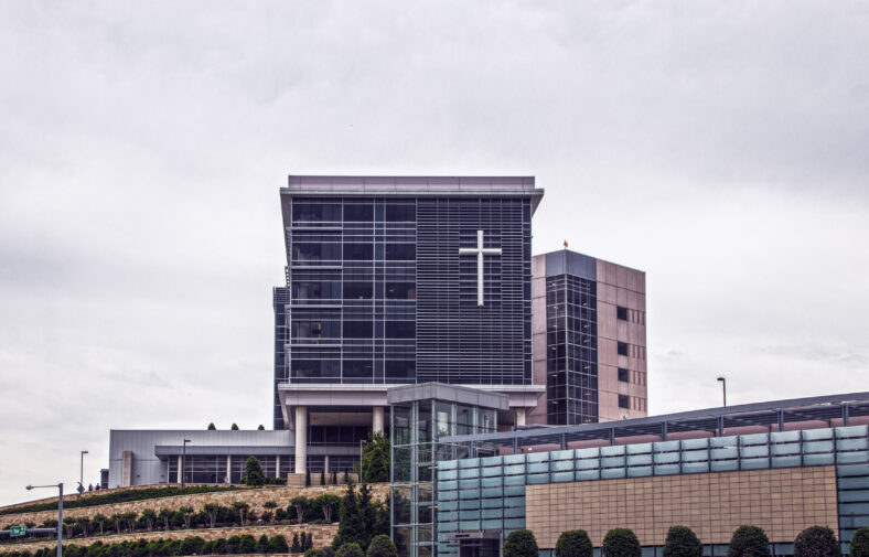 Hospital in Tulsa OKlahoma sitting up on a landscaped hill with giant cross on front windows