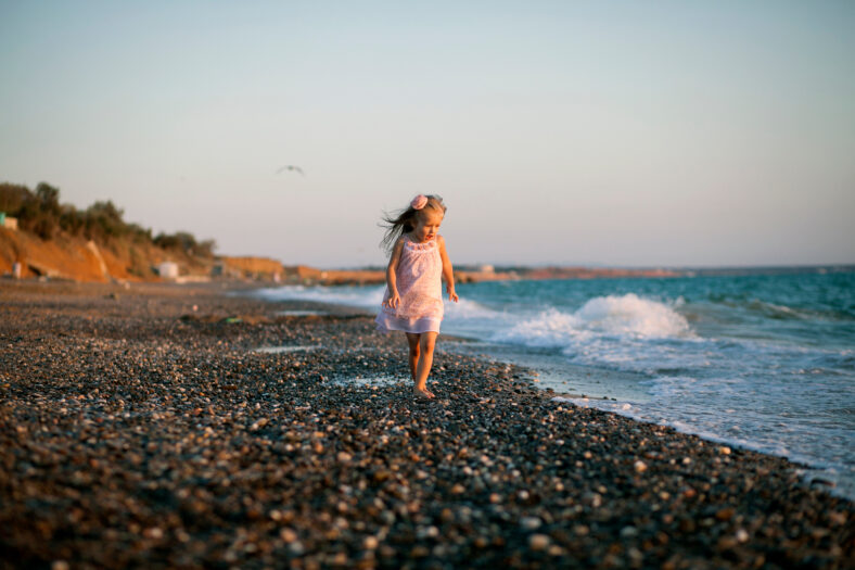 Silhouette of adorable little girl on a beach at sunset