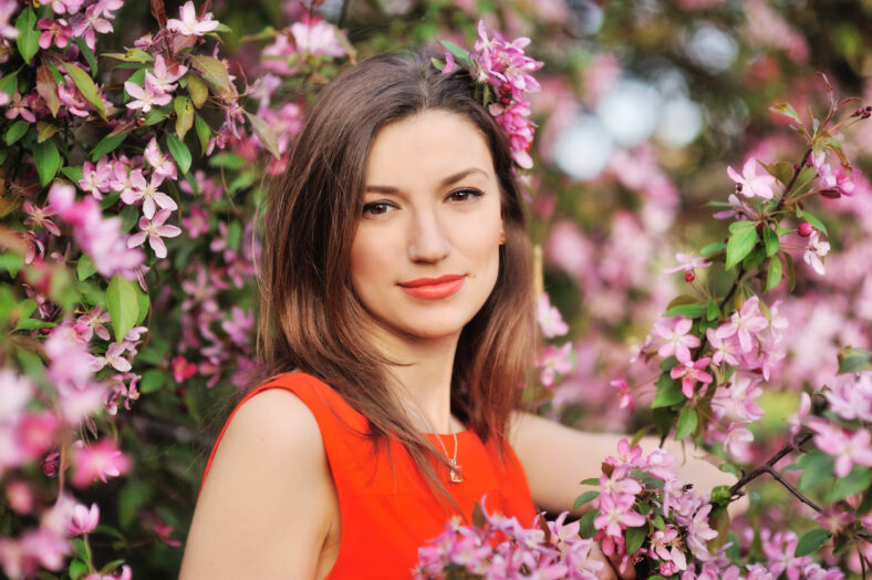 beautiful young woman in spring garden near blooming tree
