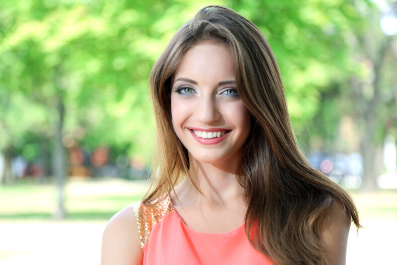 Beautiful young woman in summer park