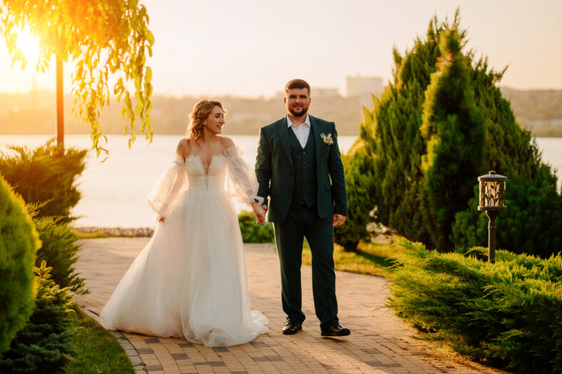 the bride and groom walk holding hands along the path. the concept of trust and a happy family life.