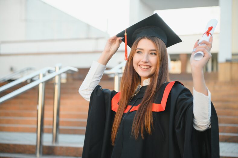 Pretty female college graduate at graduation on university campus.