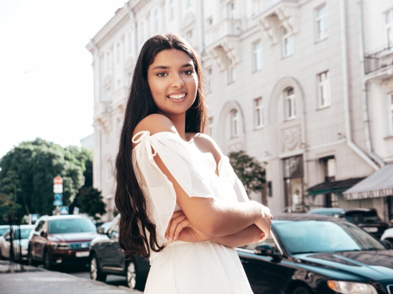 Young beautiful smiling hipster woman in white dress.