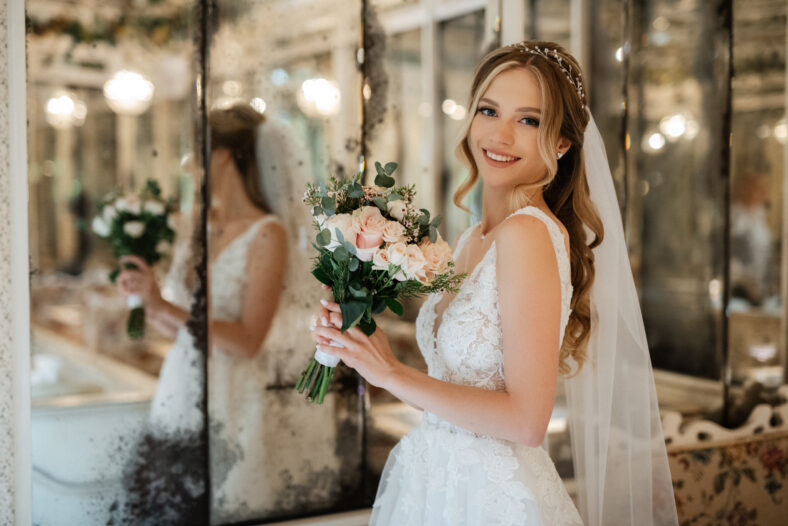 portrait of a bride in a white dress in a bright cafe with mirrors