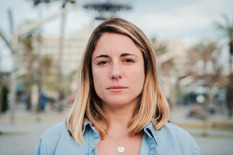 Individual close up portrait of serious young adult woman standing outside with pensive expression. Headshot of pretty confident female looking thoughtful at camera. Real formal lady staring front. High quality photo
