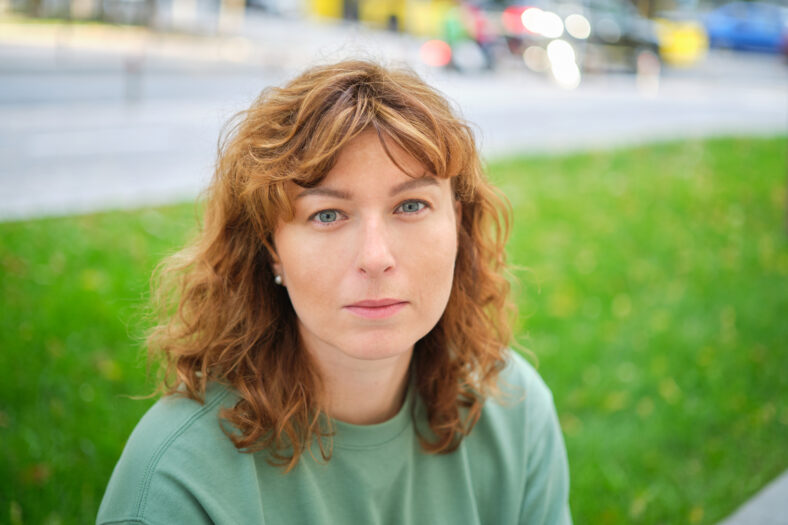 Portrait of happy mature woman looking at camera. Successful proud woman in city street at sunset. Satisfied Caucasian woman in formal clothing smiling outdoors. High quality photo