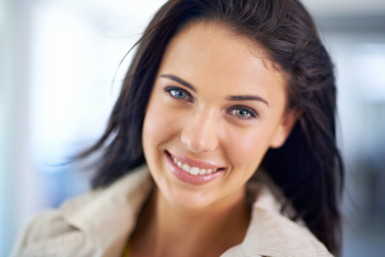 Portrait, smile and woman with happiness, confident girl and excited in a living room. Face, person and cheerful lady with fashion and long hair with pride and stylish clothes with casual outfit.