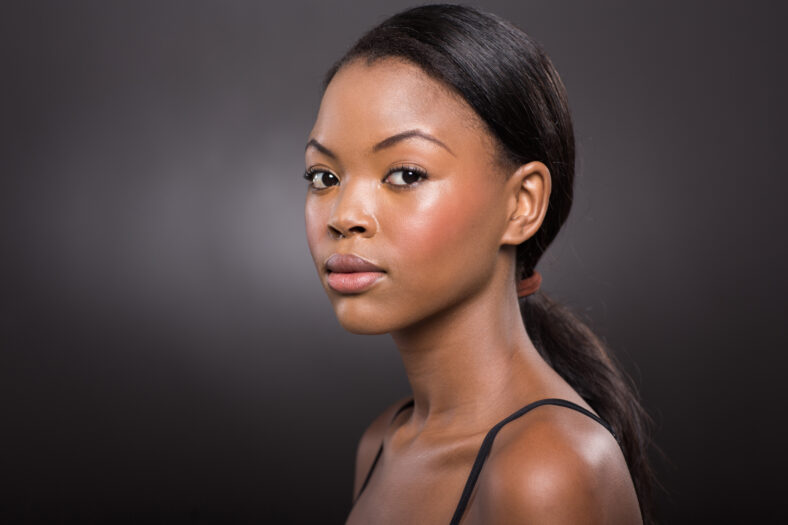 gorgeous young african american woman with natural makeup on black background