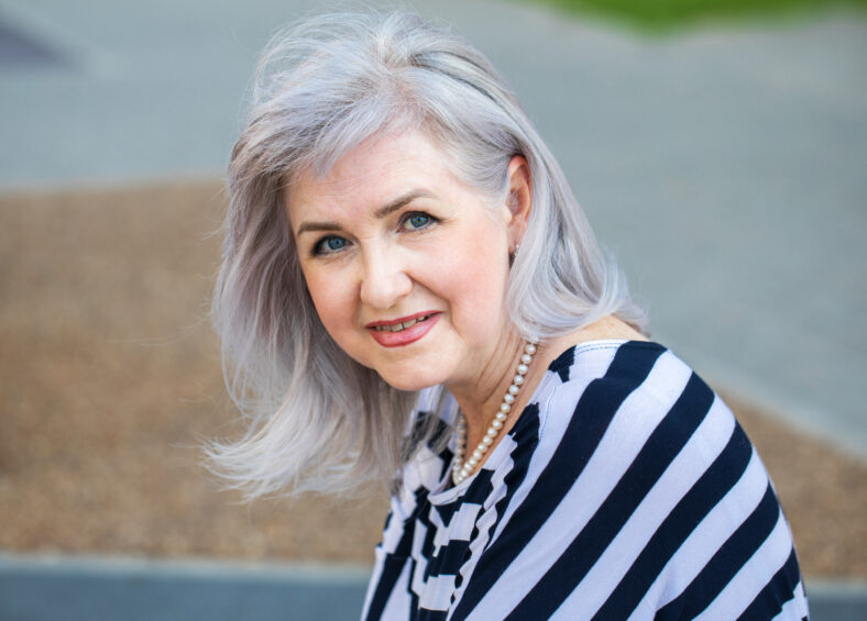 Close up portrait of an elderly gray-haired woman in a summer street