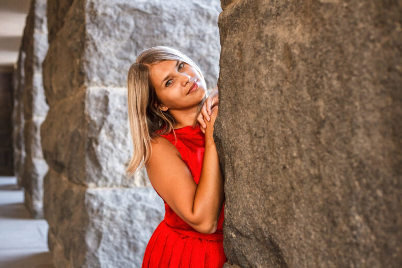 beautiful girl posing in a red evening dress in the park outdoors
