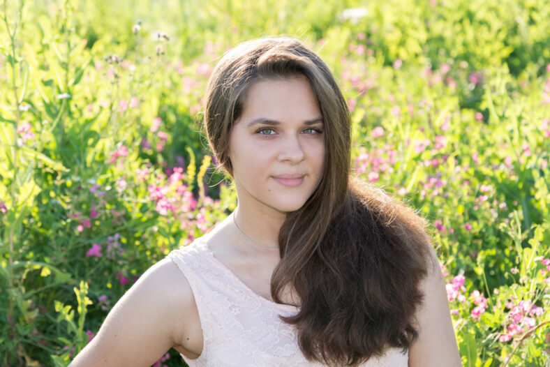 Portrait of a girl of 16 years in the flower meadow
