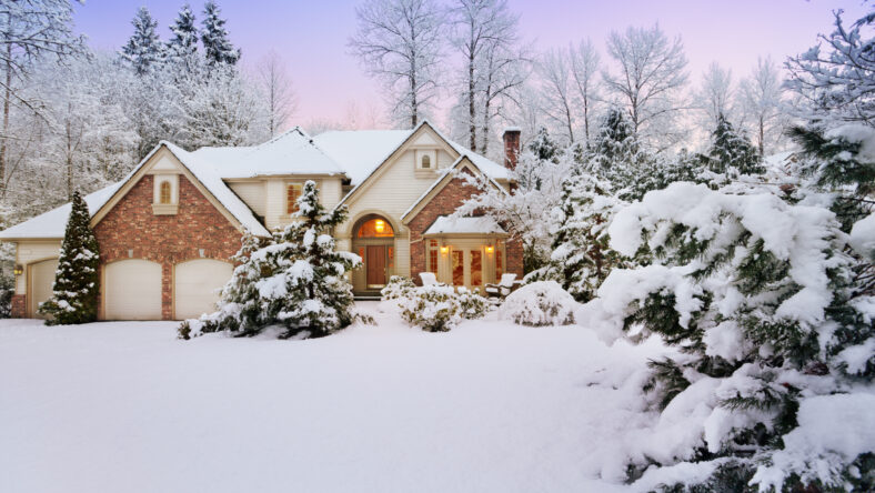 Light fades as night falls on a snowy suburban home