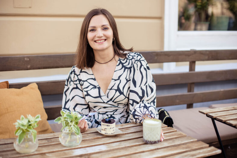 Portrait of attractive young woman in summer cafe in modern city, close-up.