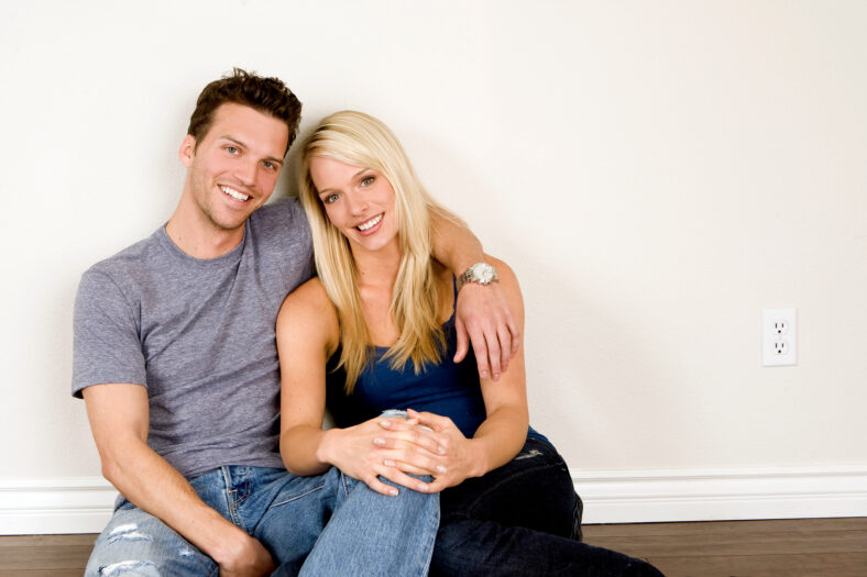 Attractive young couple sitting in their new home