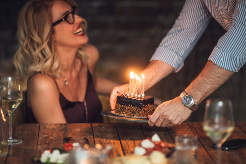 Beautiful happy blonde Caucasian woman celebrating birthday with her friends.