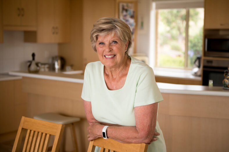 beautiful portrait of pretty and sweet senior mature woman in middle age around 70 years old smiling happy and friendly at home kitchen in aging and lifestyle concept,