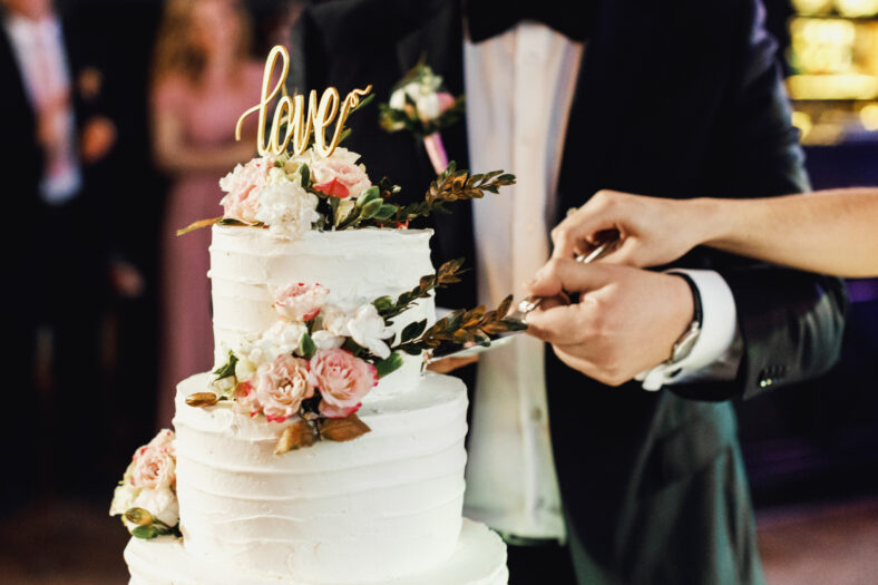 elegant pretty young bride and groom cut the wedding cake