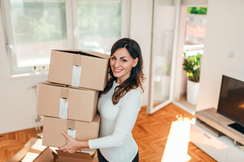 Smiling young woman moving to a new apartment.