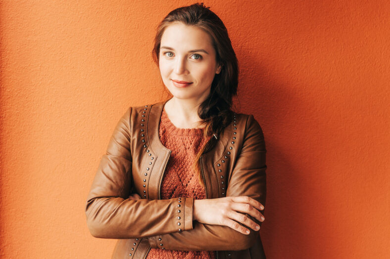 Close up portrait of beautiful young 25-30 year old woman with professional make up, wearing brown leather jacket