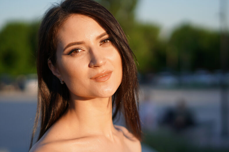 Beautiful white woman with dark hairs, portrait, face, smile.
