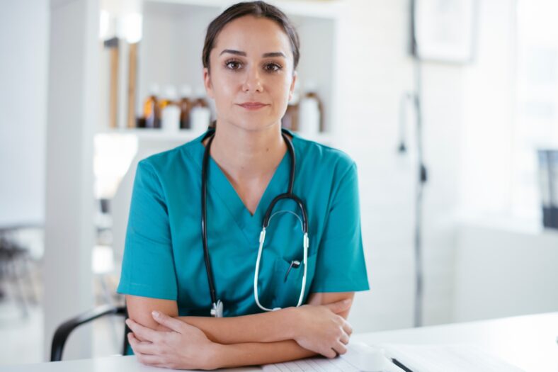 Young female doctor in medical office. Portrait of beautiful female doctor sitting in the clinic office.